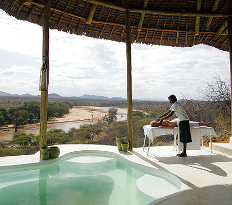 spa on a luxury safari in samburu masseur massages woman on pool deck river bank